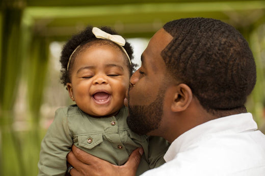 Father kissing the cheek of his baby daughter.