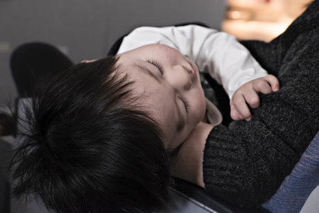 Newborn baby side lying on mother's lap