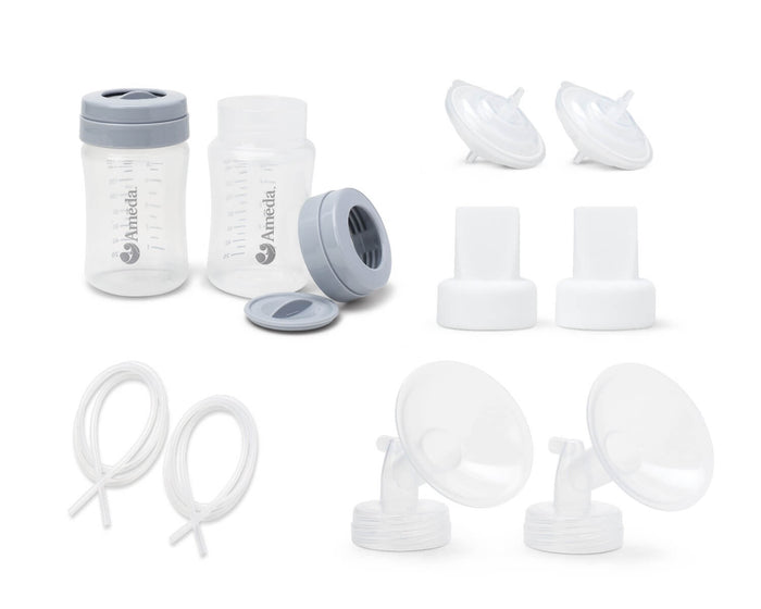 A collection of breastfeeding accessories displayed on a white background. There are two transparent plastic bottles, one with a gray screw-on lid and the other is open with a slightly wider neck. Each bottle has measurement markings on the side. There are also two additional gray bottle lids and four white pump flanges with connectors lying next to them. Two sets of white tubing are coiled on the bottom left, leading to the pump flanges, which are designed to attach to the bottles.