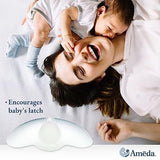 A joyful mother lies on a soft, light-colored blanket, smiling widely while holding her baby close to her face. The baby, with dark hair, affectionately touches the mother's face. The image also features a breast pump accessory at the bottom, designed to assist with breastfeeding by encouraging the baby's latch. The brand logo, Ameda, is displayed in the bottom right corner.