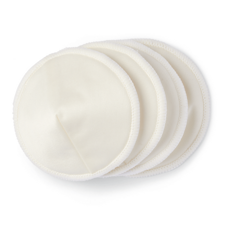 A stack of four round, soft, cream-colored fabric pads. Each pad has a smooth surface and a neatly sewn edge. The pads are slightly overlapping, creating a layered effect, and are likely designed for use in personal care, such as for breast pads or makeup removal. The background is white, emphasizing the color and texture of the pads.