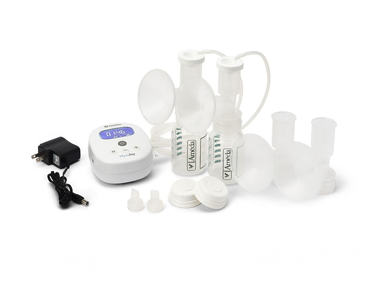 A collection of breast pump components arranged on a white background. The main items include a small white electronic pump with a digital display showing a timer reading 0:46, a power adapter connected to the pump, and several transparent plastic containers for milk collection, including two larger bottles with white flanges and tubes leading from the pump. There are also small white caps on the side and additional small components, likely for various attachments. 